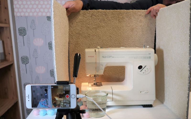 ミシンの振動対策として防音・防振マットを4点に設置し振動軽減を検証している実験写真