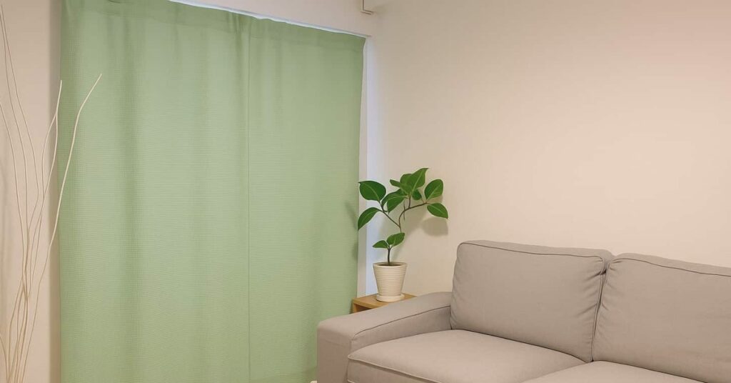 防音カーテンコーズのグリーンが生活音の防音対策として部屋の窓に設置されている