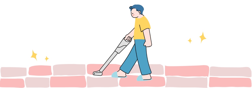 男性がカーペットを掃除機で掃除している様子